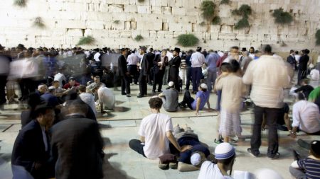 Religious Jews read from Eicha, the Book of Lamentations as they observe Tisha B’Av on August 8, 2011 at the Western Wall in Jerusalem. (Photo by Uriel Sinai/Getty Images)