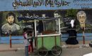 Palestinian children purchase food from a street vendor next to a Hamas police station adorned with paintings of abducted Israeli solider, Gilad Shalit, and air force pilot, Ron Arad on March 29, 2010 in Jabaliya, Gaza Strip. (Photo by Warrick Page/Getty Images)